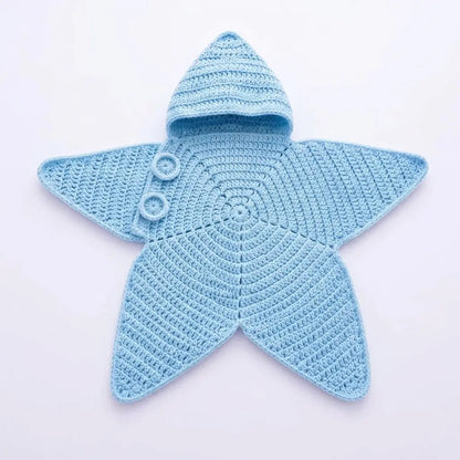 A light blue crocheted star-shaped baby outfit with a hood and two white buttons, laid flat on a white background.