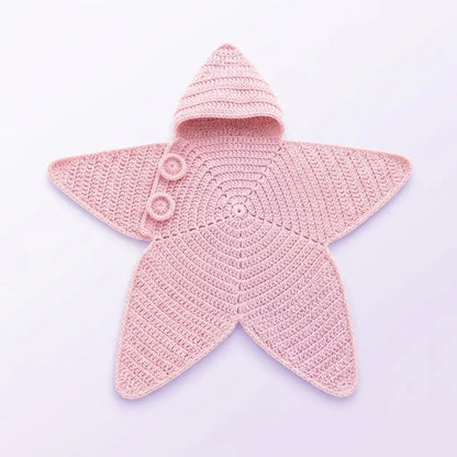 A light pink crocheted star-shaped baby blanket with a hood and two buttons, displayed on a clean white background.